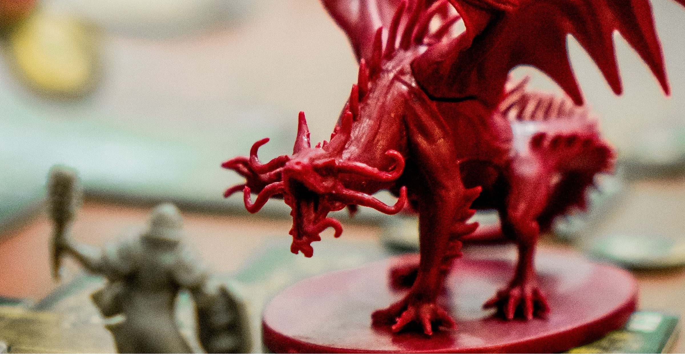 Red dragon figurine on a round base with a blurred background
